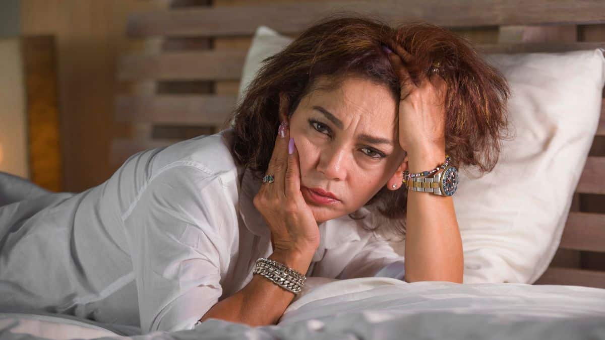 depressed woman on bed with hand in hair